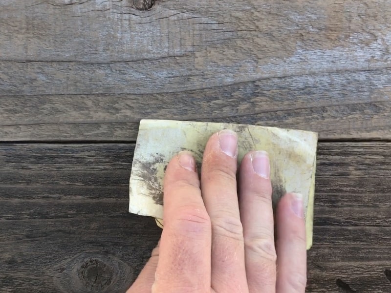 cleaning up reclaimed wood with sandpaper mountainmodernlife.com