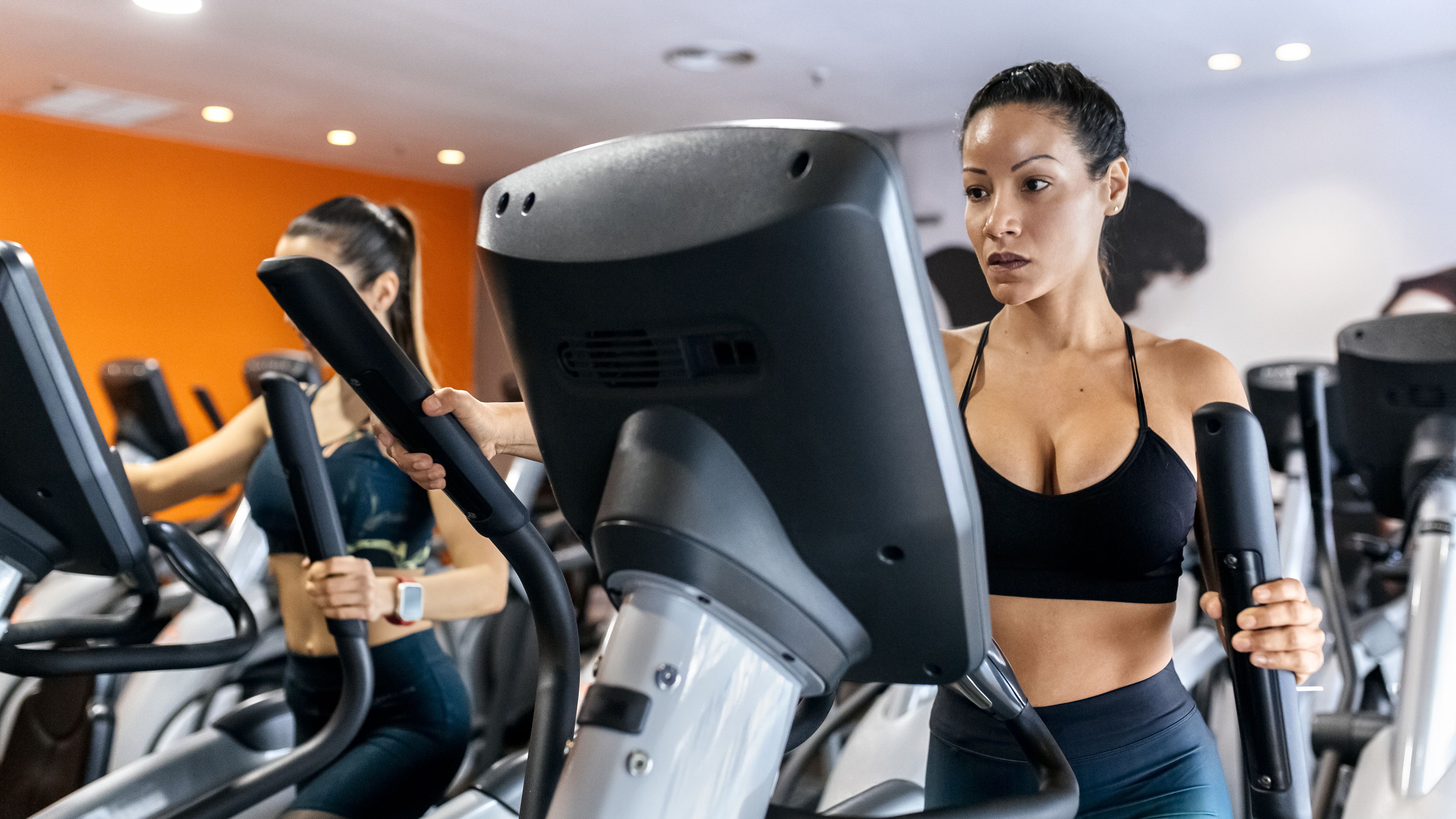 two women working out in gym using an elliptical trainer 735893505 5b34407cc9e77c005be86753